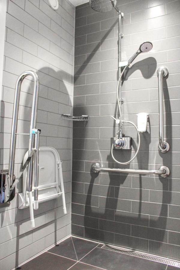 Holiday Inn Express - London Heathrow T4 By Ihg Hillingdon Esterno foto A shower stall with grab bars and a shower chair.
